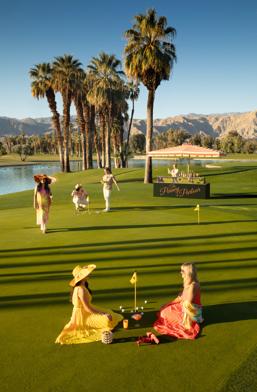 Desert Island Tipsy Hour Promo Image shows a variety of well-dressed people enjoying cocktails on the putting green at golden hour.